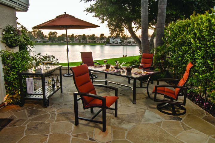 Tropitone Banchetto 66x42 Rectangular Dining Table Shown with Lakeside Padded Sling Dining and Swivel Rocker Chairs